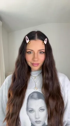 Try on a casual hairstyle with long wavy brown hair adorned with cute hair clips on the top