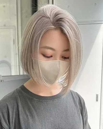 Try on a stylish short bob hairstyle with smooth, straight strands and a neat texture. The hair color is a soft, silvery blonde, adding a chic and modern look.