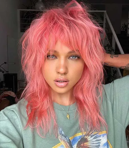 Try on this vibrant pink, shaggy hairstyle with messy, medium-length layers that add a touch of playfulness and style.