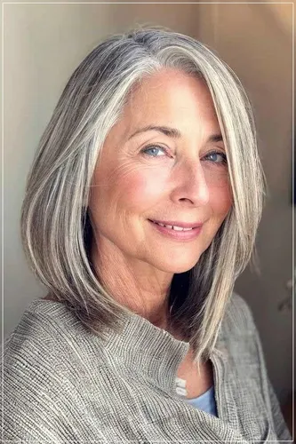 Try on this hairstyle featuring a woman with sleek, long gray hair styled smoothly falling just above her shoulders.