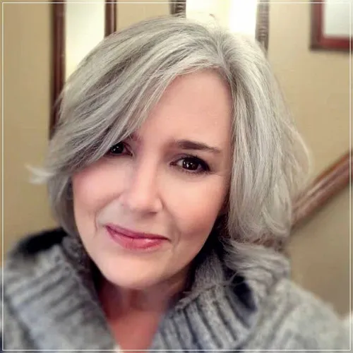 Try on a hairstyle featuring shoulder-length, wavy gray hair, framing the face softly with layers that add volume and texture.