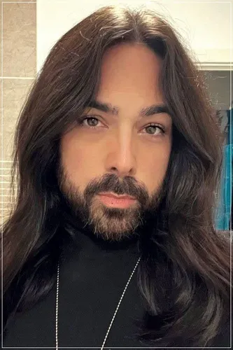 Try on this wavy, long hairstyle falling over the shoulders, providing a natural and relaxed appearance, complemented with a full beard.