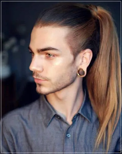 Try on a slicked back long ponytail hairstyle with this look featuring shaved sides and a neat long ponytail reaching the mid-back.