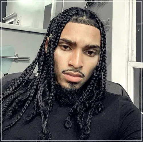 Try on a hairstyle featuring thick, long braids on a man facing forward in a casual setting. 