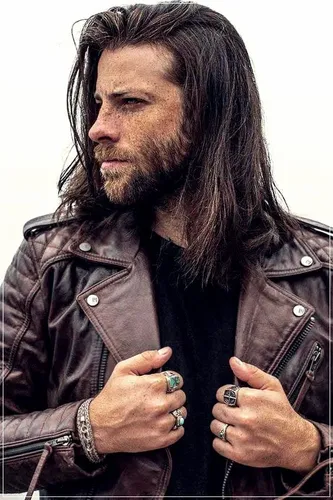 Try on a rugged long and wavy hairstyle, swept to one side with a natural flow that complements a casual or outdoor look.