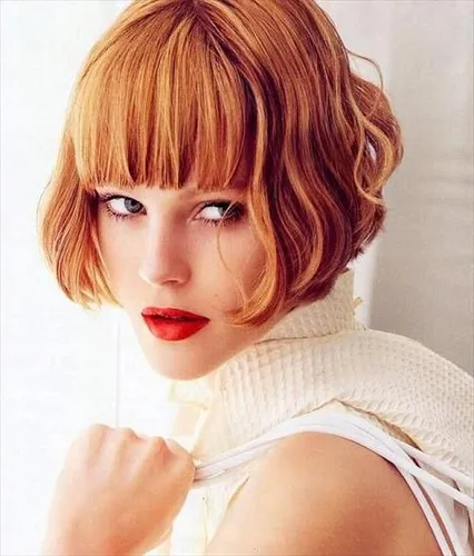 Try on this stylish bob with bangs hairstyle, featuring soft curls and a fringe just above the eyes for a chic look.
