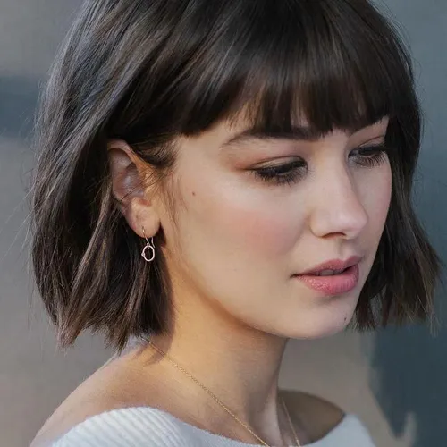 Try on this chic bob hairstyle complemented by straight-across bangs.