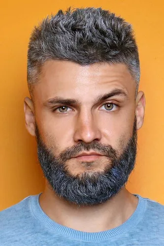 Try on the look with silver spiked hair combined with a neat, short beard, presenting a modern and youthful appearance.