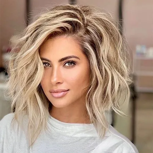 Try on this tousled, medium-length blonde wavy hairstyle that adds a touch of effortless chic to any look.