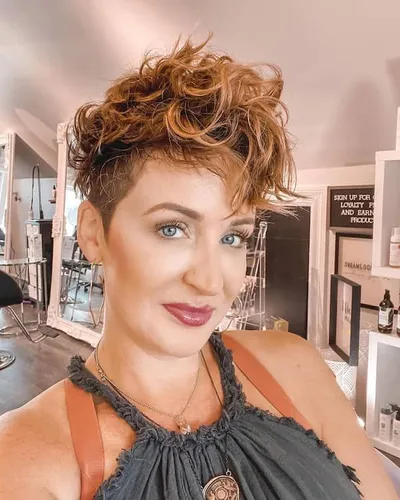 Try on this stylish short curly hairstyle with highlighted curls, complemented by a subtle undercut.