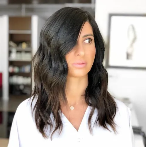 Try on this long wavy dark hairstyle that creates a soft, natural look with subtle volume and texture.