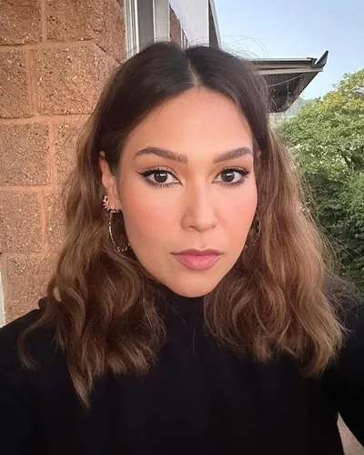 Try on this medium-length wavy hairstyle with subtle layers framing the face, ideal for adding volume and texture.