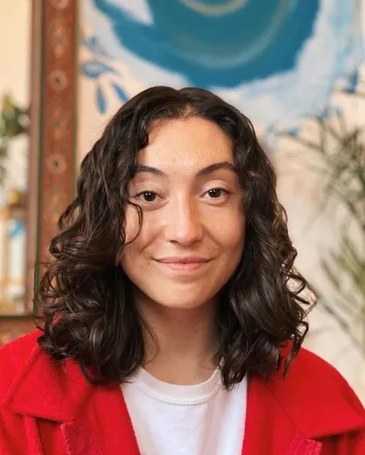 Try on shoulder-length curly hairstyle with natural curls framing the face